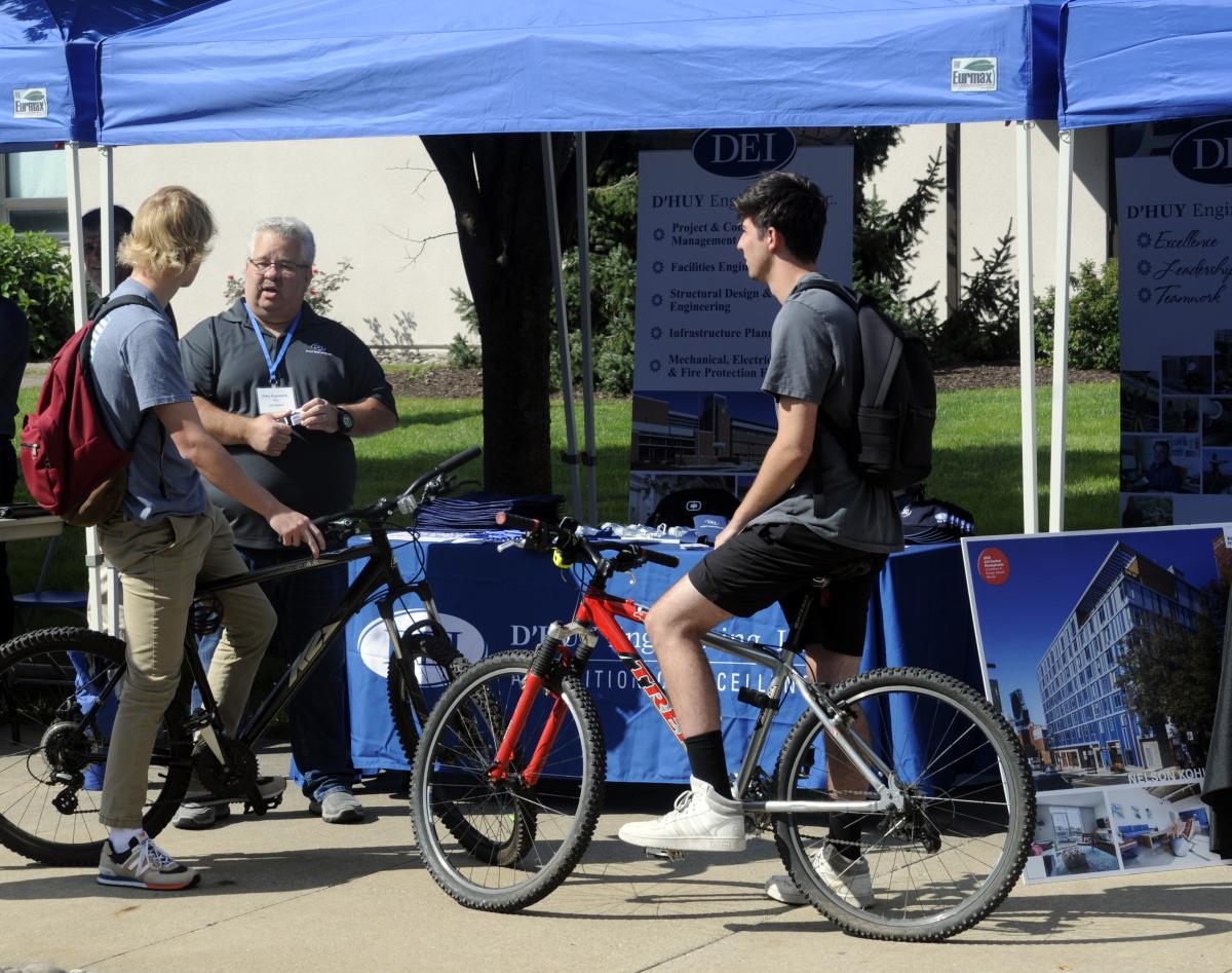 Beautiful weather made being outdoors a joy, whether walking or biking across campus. This pair of two-wheeled job-seekers stopped in their travels to chat with Jim Reinhart, from Bethlehem-based D'Huy Engineering Inc.