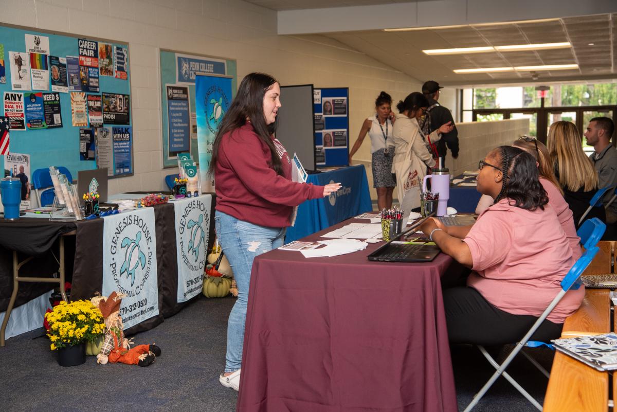 Bailey J. West (standing at left), a human services & restorative justice freshman from Perryville, Mo., speaks with representatives at the Families United Network Inc. table, including human services alumna Latricia M. Scutching (seated at right), residential therapist. 