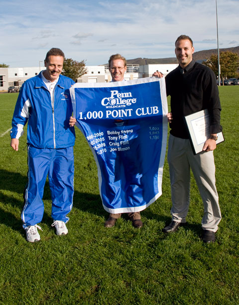 Bobby String, right, also awarded an alumni athletic award, holds a 1,000 Point Club banner with Wildcat basketball coach Gene Bruno, left, and Douglas T. Byerly, director of athletics. A guard on the Wildcat mens basketball team in 1999-2000, String scored 1,022 points to become the first player in school history to reach that mark.