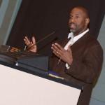 With a stack of DVDs at his side, Byron Hurt answers audience questions after the showing of "Soul Food Junkies."