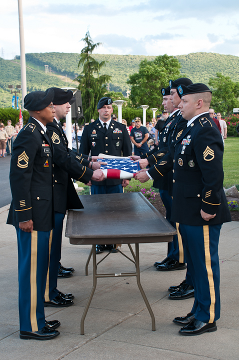 Thirteen folds into a tight triangle: Military personnel crisply demonstrate the proper way to fold the flag.