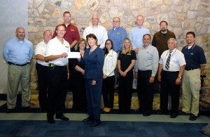 Cleveland Brothers Equipment Co. Inc.'s Randy Fetterolf delivers a Caterpillar contribution to Mary A. Sullivan, executive director of Penn College's Schneebeli Earth Science Center and assistant dean of transportation and natural resources technologies. Second row, from left, are Ray Boucher and Gary Shields, Alban Tractor Co. Inc.; Patricia Pring, Cleveland Brothers; Donna Evans, Ransome CAT; Melissa Charest and Carl Bisesi, H.O. Penn Machinery Inc.; Colin W. Williamson, dean of transportation and natural resources technologies; and Chris S. Weaver, instructor of diesel equipment technology. Back row, from left: Rusty Steele, Alban; Ron Garber, Ransome; James Chianese, H.O. Penn; Karl Quinn, Alban; and Justin W. Beishline, instructor of diesel equipment technology.