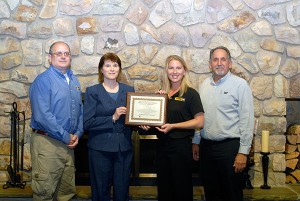 Mary A. Sullivan (second from left), executive director of Penn College's Schneebeli Earth Science Center and assistant dean of transportation and natural resources technologies, presents a 15-year participation award to H.O. Penn Machinery Inc. representatives James Chianese (left), Melissa Charest and Carl Bisesi.