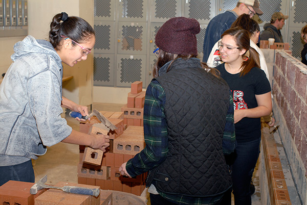 Building construction technology: masonry emphasis major Nicole Reyes-Molina, of Lancaster, demonstrates for visitors.