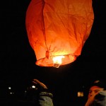 Buoyed by the heat inside, another lantern rises into the night sky.