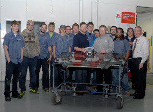 Jeff Klingman (fifth from right), Axalta territory sales manager, joins Penn College collision repair instructor Loren R. Bruckhart (center); Brett A. Reasner (right), dean of transportation and natural resources technologies; and students in the College Avenue Labs paint laboratory. Bruckhart is holding an Axalta-donated digital spectrophotometer, a handheld color-matching device.