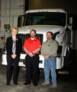 Gathered near a newly acquired Volvo truck are (from left) Elizabeth A. Biddle, Penn College’s director of corporate relations; alumnus Greg A. Moser, who, as a district fleet maintenance manager for FedEx Freight, arranged donation of the 2006 vehicle; and Mark E. Sones, a diesel equipment technology faculty member.