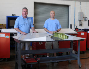 Alumnus David J. Barr (right) is joined by Brett A. Reasner, Penn College’s dean of transportation and natural resources technologies, after delivering a sizable equipment donation from Airbus to the Lumley Aviation Center.