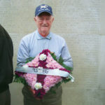 Raymond Eck, '41, lays a wreath at Madingley American Cemetery in England.