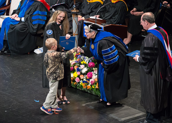 On Mother's Day weekend, a boy fittingly shares the commencement limelight (and acknowledgement of his loved one's accomplishment by the president and board member John Young).