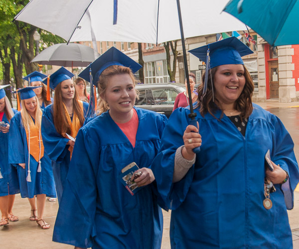 Umbrellas shield students from the rain in a shortened walk to the Community Arts Center.