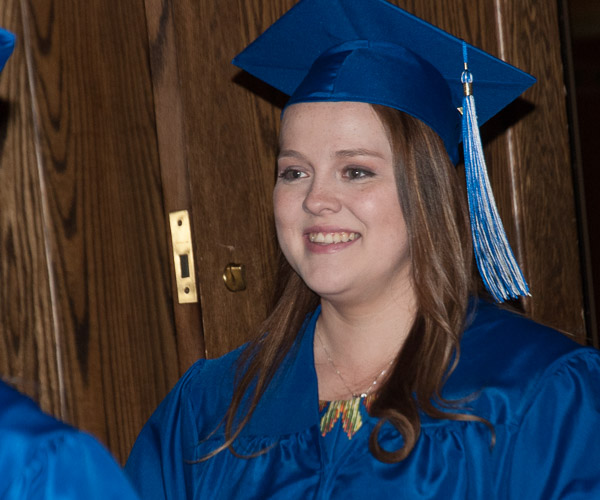 A newly minted graduate exits the theater with appropriate joy.