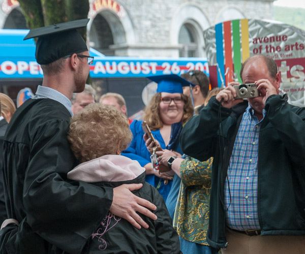 A grad gathers with family for a photo.