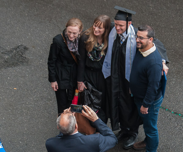 As morning graduation crowds thin, a family gets a clear shot in West Fourth Street.