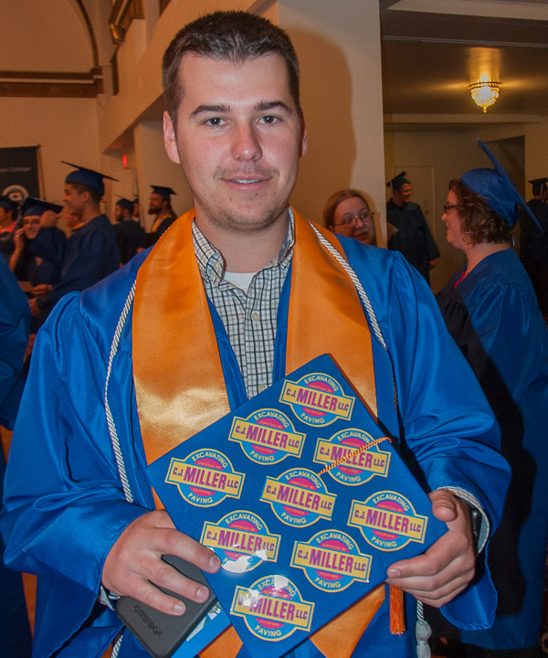 Ryen M. Persun, of Linden, shows off a true degree that works, adorning his cap with the logo of his new employer, C.J. Miller Excavating and Paving, where he’s been hired to begin work as an assistant project manager. Persun received a degree on Saturday in business management.