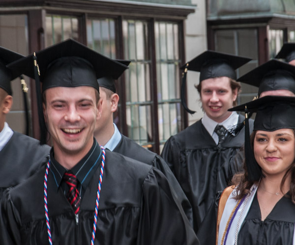 Grads' smiles light up a cloudy afternoon as they head to the theater.