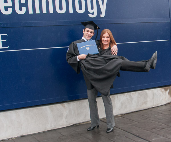 Never too old for a pick-me-up from Mom, Carlos A. Ramos-Sonera celebrates in front of the Penn College sign.