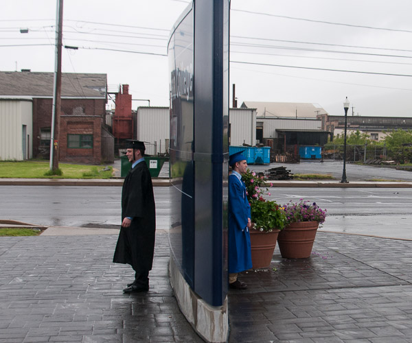 Flipside: Grads on both sides of the sign try to capture their Penn College memories.