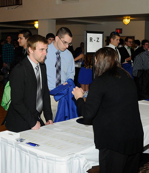 Lizze A. Robinholt, external records evaluator in the Registrar's Office, explains grads' 