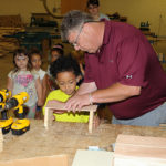 With materials arrayed before him and classmates waiting their turn behind him, Ghazi sets the pace for hands-on learning.