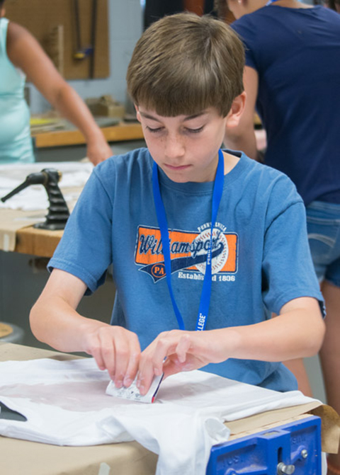 A Creative Art Camp attendee, intent in his handiwork