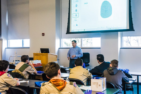 Chris E. Miller, police chief and director of campus safety, schools Boy Scouts on crime-scene investigation.