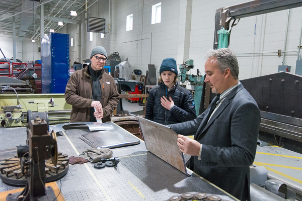 Roy H. Klinger, instructor of collision repair, shows visitors an example of his department’s work.