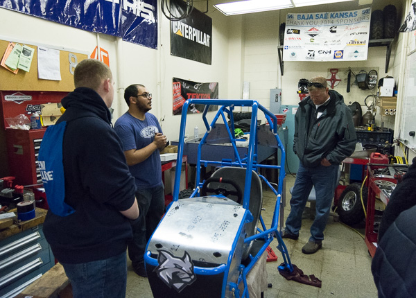 In the Machining Technologies Center, manufacturing engineering technology student and Baja team member Shujaa AlQahtani, of State College, talks with visitors about the off-road vehicles that students build each year for competition.