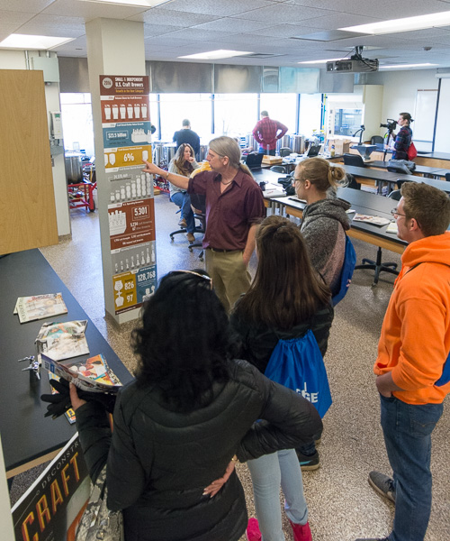 Timothy L. Yarrington refers to a visual aid as he talks with visitors about the college’s brewing and fermentation science degree.