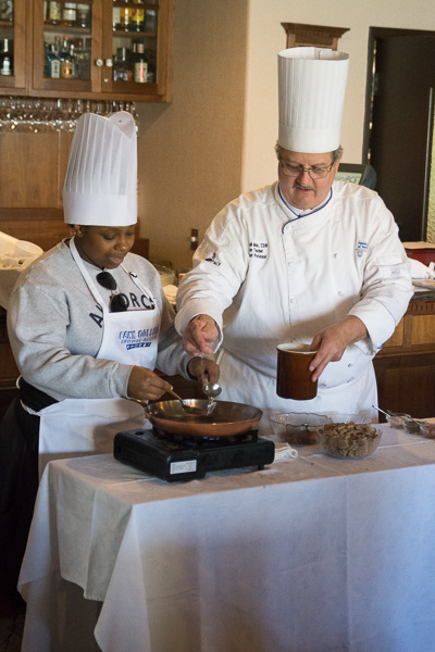 A prospective student helps Chef Paul Mach, assistant professor of hospitality management/culinary arts, with a demonstration in Le Jeune Chef Restaurant, a live-learning lab for the School of Business & Hospitality.