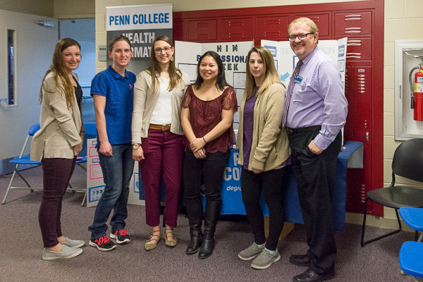 Health information technology students, joined by Dan Christopher, assistant professor of health information technology, greet people in the west wing of the Advanced Technology and Health Sciences Center.