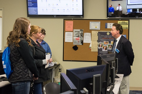 Roy A. Fletcher, assistant professor of banking and finance, speaks with guests about business degrees in the Financial Markets Lab.