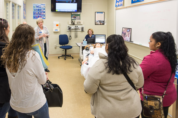 Visitors tour the nursing program’s pediatrics/labor and delivery lab. 