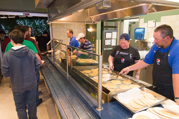 Joining the Residence Life/Athletics team of cooks and servers is Wildcat baseball coach Chris Howard (foreground), showing his prowess with a different kind of batter, indeed.