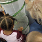 Youngsters assess a portable butterfly garden, complete with the monarch's habitat of choice: milkweed.