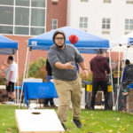 Community Peer Educator Alexis J. Medero lofts a beanbag toward its target.