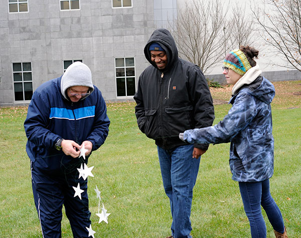 Veterans Work Study student Efrem K. Foster (center), of Williamsport, graduating next month in applied management, and Emily J. Jones, an accounting major from Avis, offer moral support as Beaver untangles a jumble of wire.