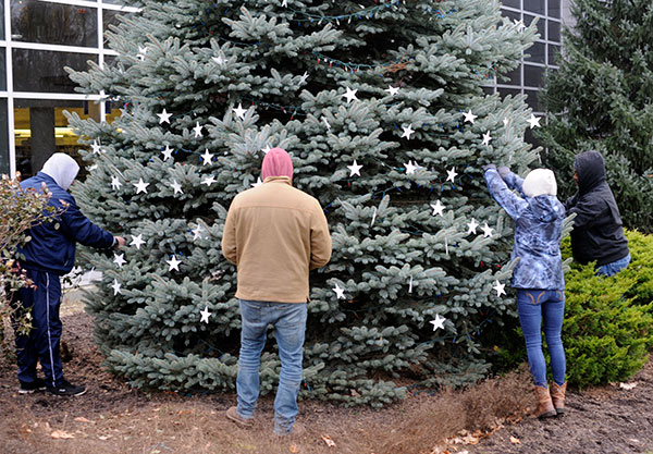 With the upper-level stars aligned, the team hand-places the remaining ornaments. From left are Beaver; Brandon R. Belack, of Halifax, a surveying technology major and Veterans Work Study student; Jones and Foster.