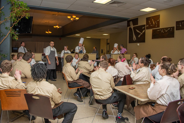 Students and faculty applaud Chefs Uribe and Erceg (second and third from left) at the start of the traditional staff “lineup” before guests arrive. 