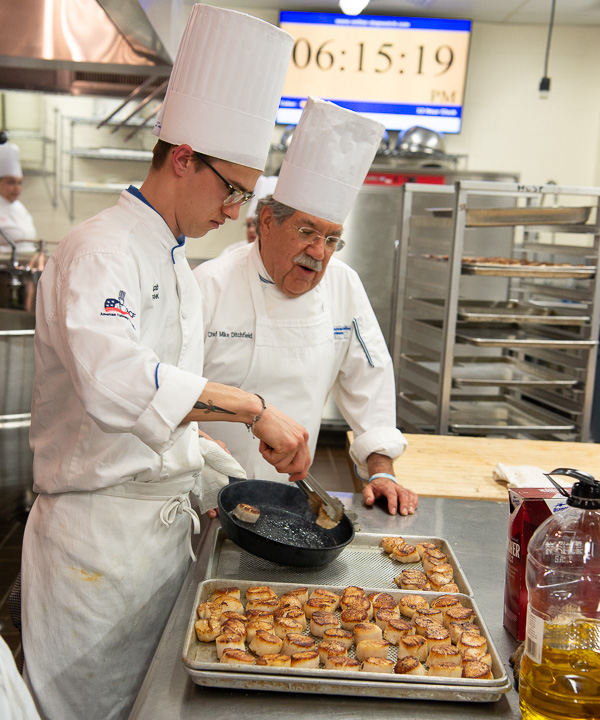 With time ticking down, Jacob W. Parobek, culinary arts and systems, and Ditchfield oversee the first course: seared sea scallops. 