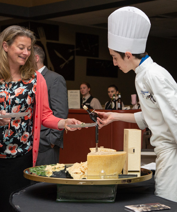 Kobi A. Shannon, culinary arts technology, drizzles balsamico on chunks of Parmigiano Reggiano. 