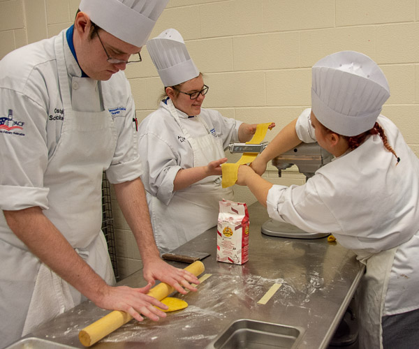 A three-student team rolls pasta dough. From left are Christopher J. Schreckengost, of Cadogan; Angela M. Linde, of Harrisburg; and Lauren N. Meszaros, of Starrucca.