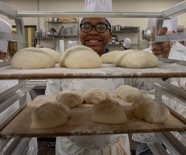 Student Ashley L. Yancey, of Abington, loads sourdough loaves onto a cart.