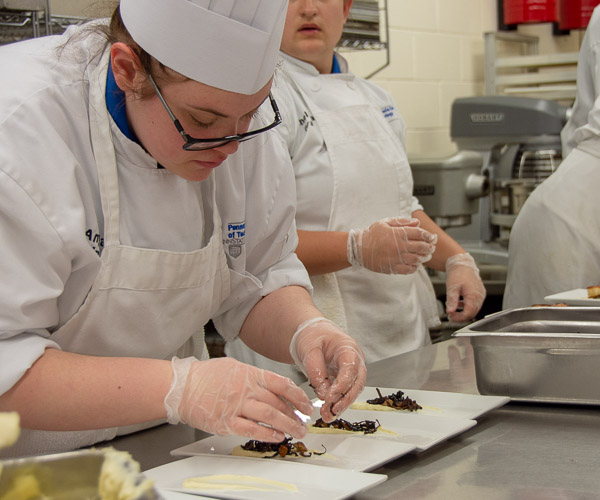 Angela M. Linde, of Harrisburg, adds mushrooms to the first course …