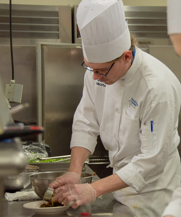 Garrett E. Mottern, of Hughesville, adds fresh tuna to the second course.