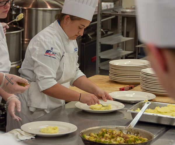 Culinary arts technology student Chelsea L. Gray, of Marysville, adds Rubichon potatoes to the main course.