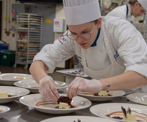 Bailey L. Frey, a baking and pastry arts student from Watsontown, adds an element to the tiramisu semifreddo.