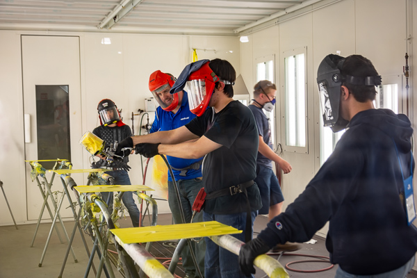 Steady-handed Automotive Restoration campers practice in a College Avenue Labs paint booth.