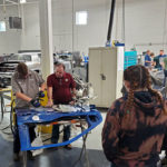 ... before letting automotive restoration technology student Jim A. McCormick, of Pittsburgh, try his hand with the dent-repair equipment.