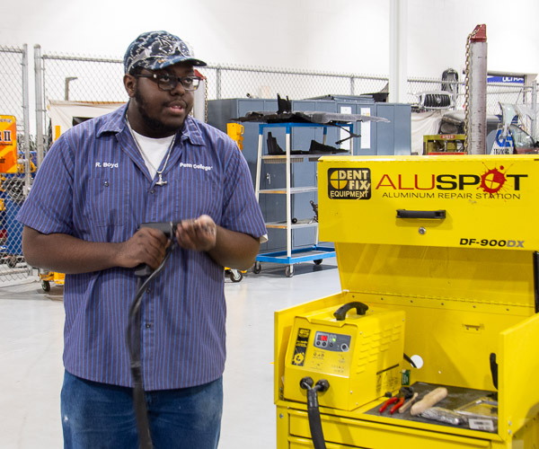 … while Romoi R. Boyd, a collision repair technology student from Lock Haven, demonstrates an aluminum repair system.